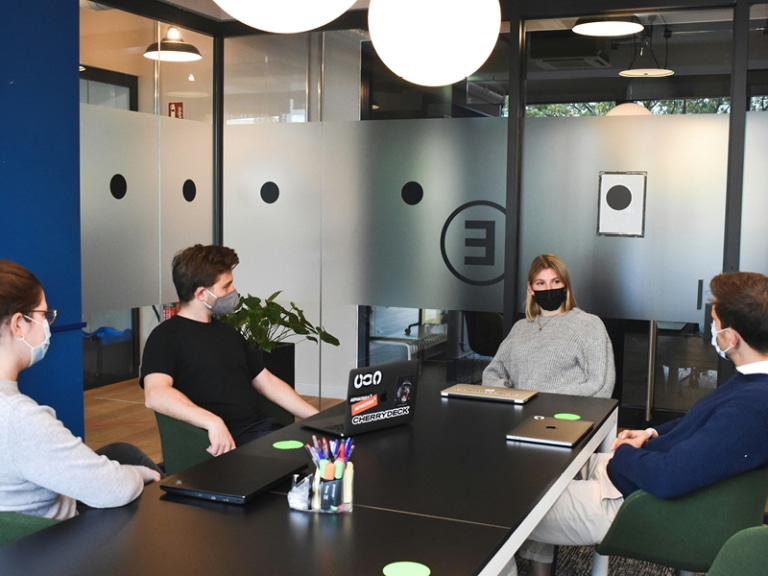 4 colleagues collaborate together in covid 19 face masks