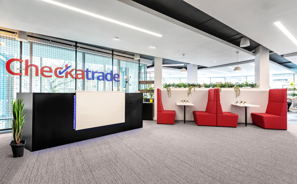 Checkatrade reception desk with red booth seating and Checkatrade logo