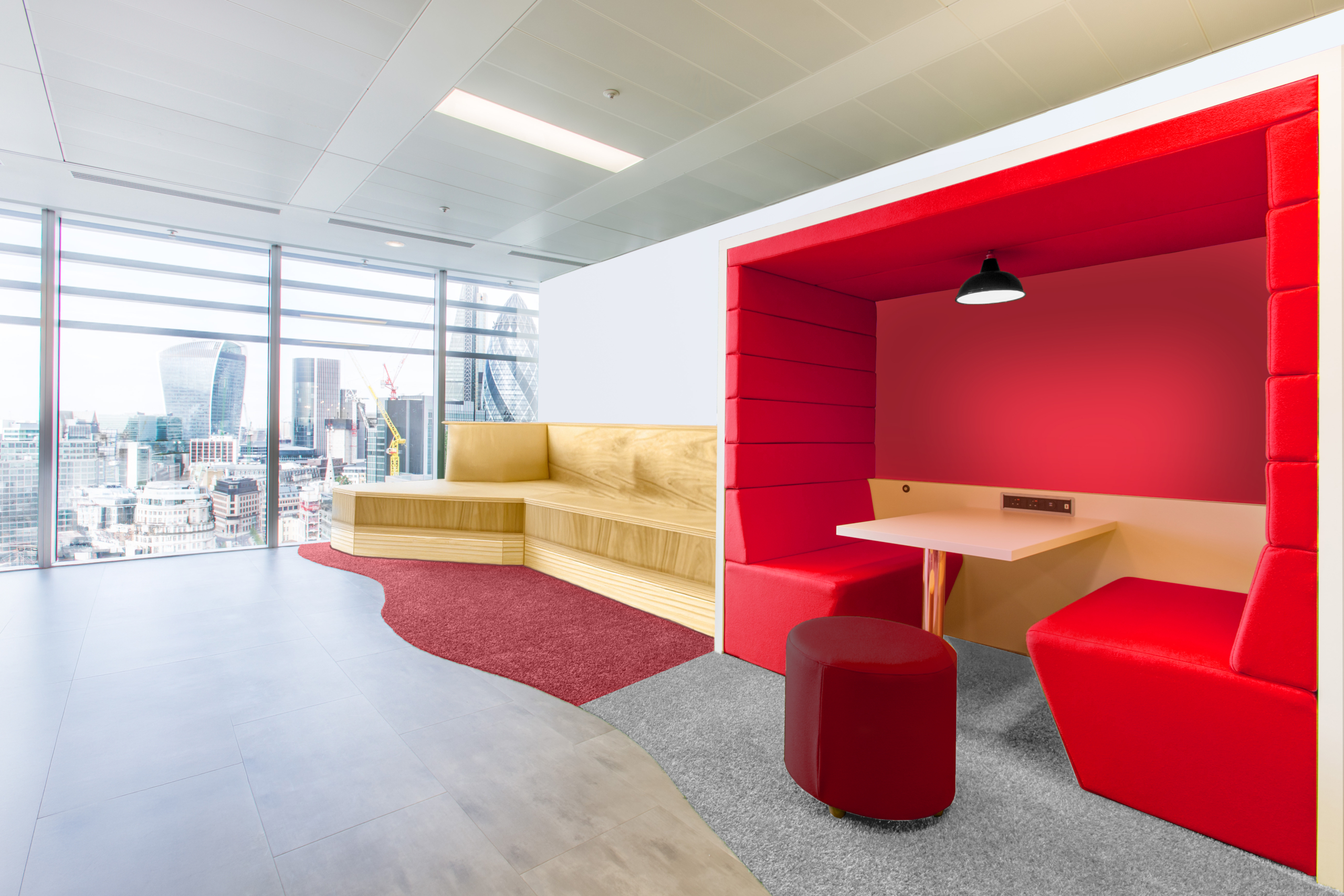 Red breakout area with wooden seating area and red poof