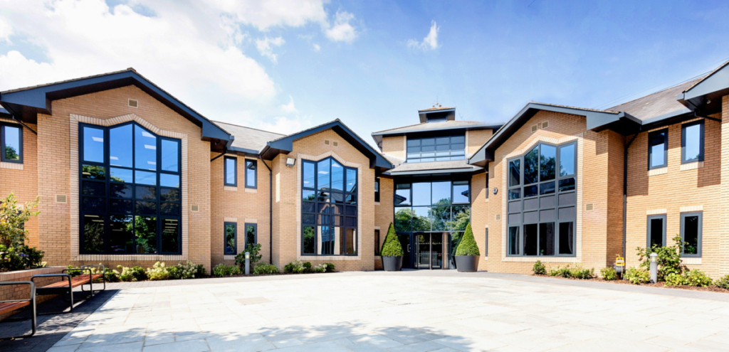 Aerial Direct office exterior shot with blue sky and greenery